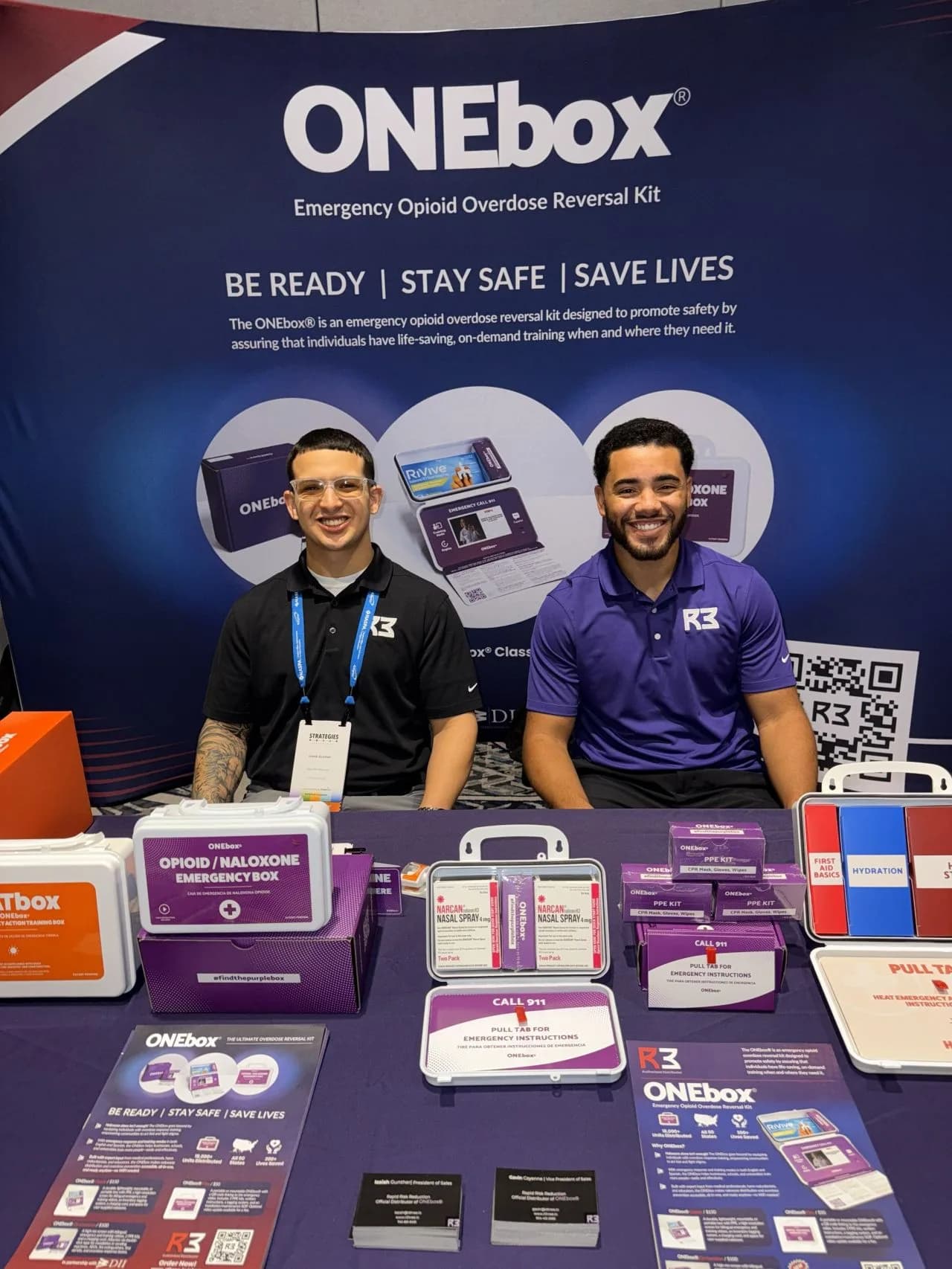 R3 team members presenting ONEbox® kits at an event table